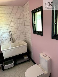 a white toilet sitting next to a sink in a bathroom under two mirrors on the wall