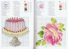 the cross stitch book is open to show an image of a cake and flowers