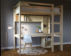 a loft bed with a desk underneath it in a room that has hardwood floors and gray walls