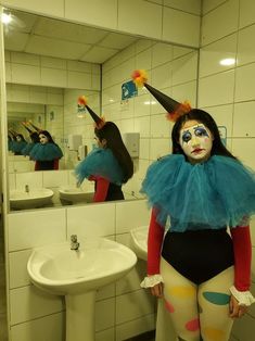 a woman with clown makeup standing in front of a bathroom mirror