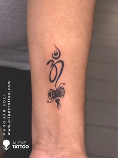 a tattoo on the wrist of a woman with an omen symbol in black ink