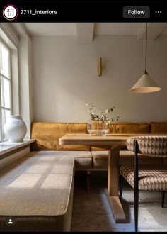 a living room filled with furniture next to a window and a vase on top of a table