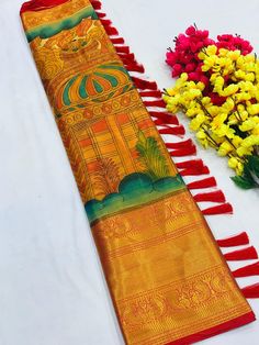 two long red and yellow tassels next to some flowers on a white surface