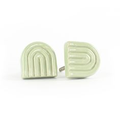 a pair of green ceramic cufflinks with the letter e on it's side