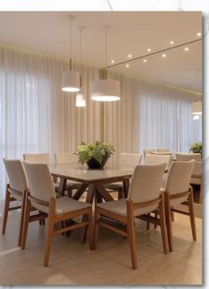 the dining room table is surrounded by white chairs