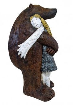 a statue of a bear holding a woman's head with her arms wrapped around it