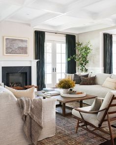 a living room filled with furniture and a fire place in front of a fireplace surrounded by windows