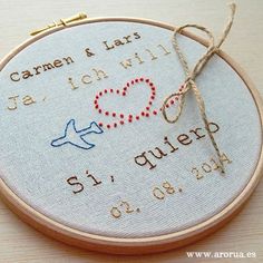 a close up of a embroidery on a wooden hoop with an embroidered heart and the words i love you