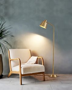 a chair with a lamp on it next to a potted plant