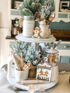 three tiered christmas tree with gingerbread cookies in jars and cookie cutters on top