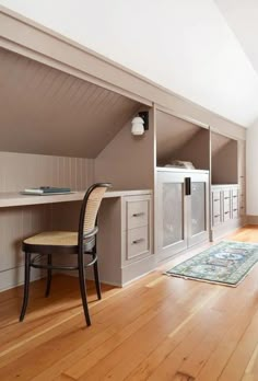 an attic bedroom with wooden floors and white walls, built in shelving units on the wall