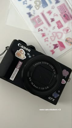 a camera sitting on top of a table next to a sticker and paper sheet