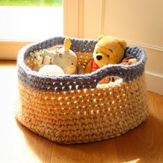 a stuffed animal in a basket on the floor