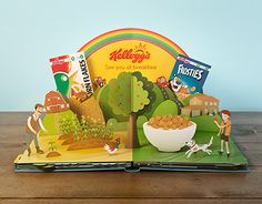 an open children's book with pictures of food and people on the pages, sitting on a wooden table