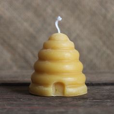 a small yellow candle sitting on top of a wooden table