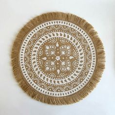 a brown and white doily with fringe on it