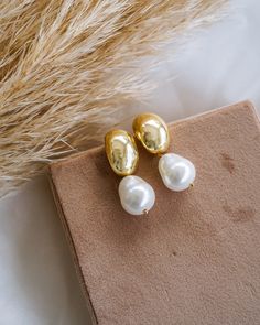 Make a timeless statement with these chic Hailey Dome Pearl Drop Earrings! Crafted in gold and featuring an elegant pearl, these earrings will be a beautiful addition to your collection. Slip them on for a sophisticated finish to any look! EARRINGS FEATURE Material: Brass, Shell Teardrop Pearls Finish: 14K Gold Filled Size: 17.9mm x 11.8mm x 18.9mm, Pearl Size 10mm x 12mm Lead & Nickel-Free Wedding Day Pearl Earrings, Luxury Gold Pearl Embellished Earrings, Chic Yellow Gold Pearl Earrings For Wedding, Classic Pearl Drop Earrings For Everyday Elegance, Refined Gold Pearl Drop Earrings, Gold Timeless Bridal Earrings For Wedding, Timeless Gold Bridal Earrings For Evening, Timeless Elegant Drop Pearl Earrings, Timeless Everyday Pearl Drop Earrings