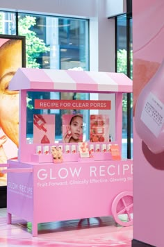 a pink ice cream stand in the middle of a mall with an advertisement for glow recipe on it