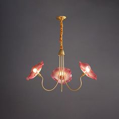 a chandelier with three pink flowers hanging from it's arms and two lights on each side