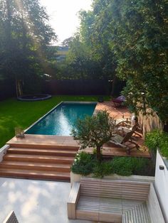 an outdoor pool with steps leading up to it and trees in the backround