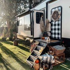 an rv parked in the grass with its door open and some decorations on the ground