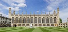 the large building has many windows on it's sides and is surrounded by green grass