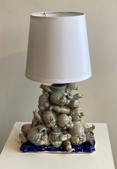 a lamp that is sitting on top of some kind of animal figurine with a white shade