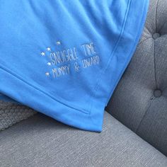 a blue tshirt sitting on top of a gray couch