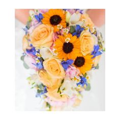 a bride holding a bouquet of sunflowers and roses