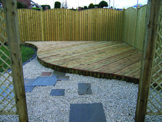 a wooden deck surrounded by stones and gravel