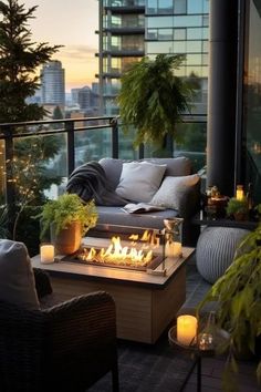 an outdoor fire pit on a balcony with candles and potted plants in the foreground