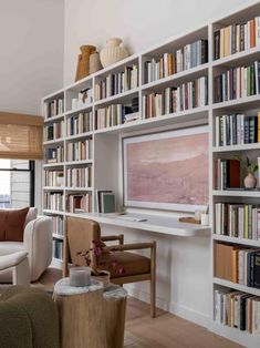 a living room filled with furniture and lots of bookshelves full of books on top of them