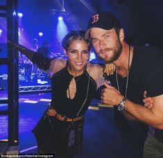 a man and woman posing for a photo in front of a stage with blue lights