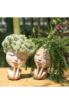 two ceramic heads with plants growing out of them