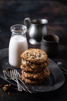 two cookies on a plate next to a glass of milk