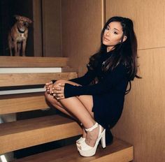 a woman sitting on some stairs with her legs crossed