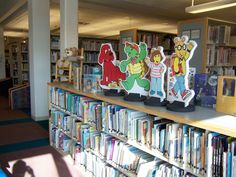 the bookshelves in the library are filled with children's books and stuffed animals