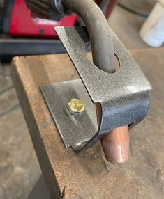 a piece of metal is being worked on with a vice and wrench in the foreground