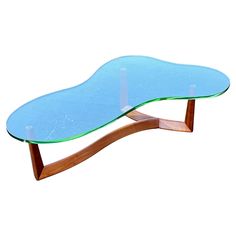 a glass and wood coffee table with curved legs