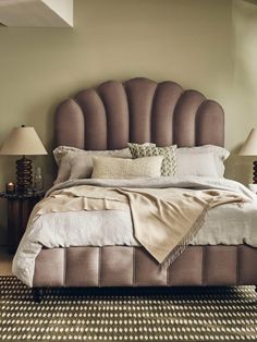 a bedroom with a large bed and two lamps on either side of the headboard