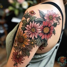 a woman's shoulder with flowers and leaves tattooed on her left upper half sleeve