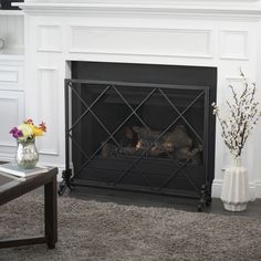 a living room with a fire place and vases filled with flowers on the floor