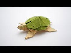 a green origami turtle sitting on top of a white table