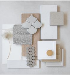 an assortment of different materials are arranged on a table with white and gold accents,