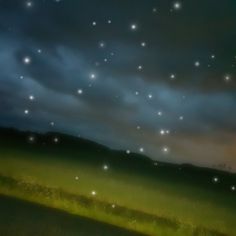 the night sky is full of stars and some green grass in front of dark clouds