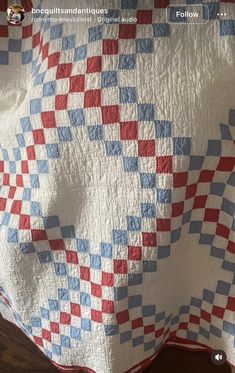 a red, white and blue checkered quilt on a bed