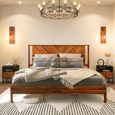 a bedroom with a bed, dresser and chandelier in it's center