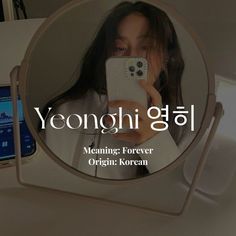 a woman taking a selfie in front of a mirror with the words yeongghi on it