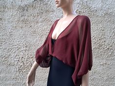 Sheer silk mousseline chiffon 100% crop jacket with balloon sleeve in burgundy and white color. This silk transparent crop jacket is a stylish and versatile piece that adds a touch of elegance to any outfit. The transparent design allows for a subtle peek at the clothing underneath, while the cropped length and flowing silk fabric provide a flattering and feminine silhouette. The 3/4 sleeves add a luxurious touch and make this bolero shrug perfect for pairing with evening dresses or formal attir Elegant Fitted V-neck Shrug, Elegant Formal Crop Top For Spring, Elegant Cropped Spring Shrug, Elegant Cropped Shrug For Spring, Elegant Spring Formal Crop Top, Cropped Shrug For Spring Party, Spring Party Cropped Shrug, Elegant Formal Summer Crop Top, Elegant Sheer Crop Top For Evening