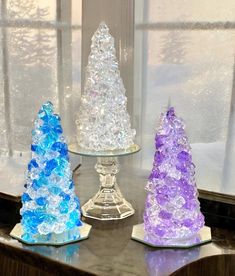 three glass trees sitting on top of a table